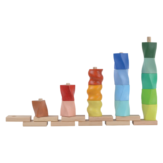 A set of colorful twisted geometric shapes placed on height rods, with the shortest rod for a yellow piece and the highest rod for a green piece, all lined up in a row.