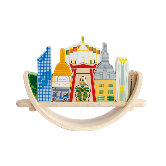 A colorful balancing toy set representing a Bangkok cityscape, with various landmarks trying to balance on a crescent base.