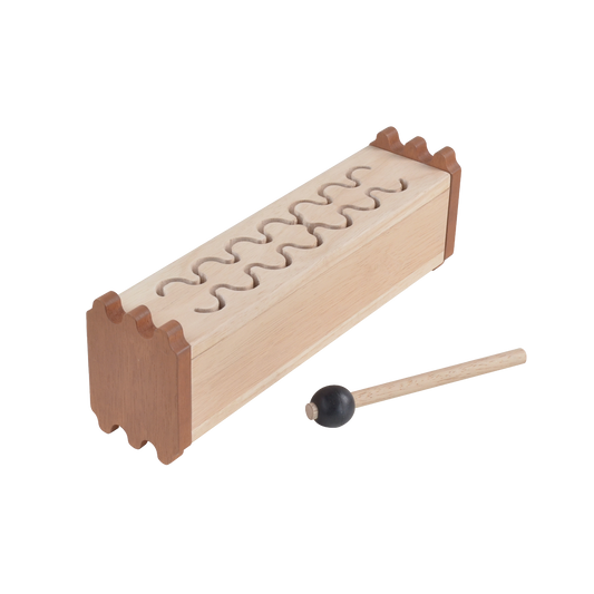 A wooden tongue drum with a metal beater, used as a musical instrument for children.