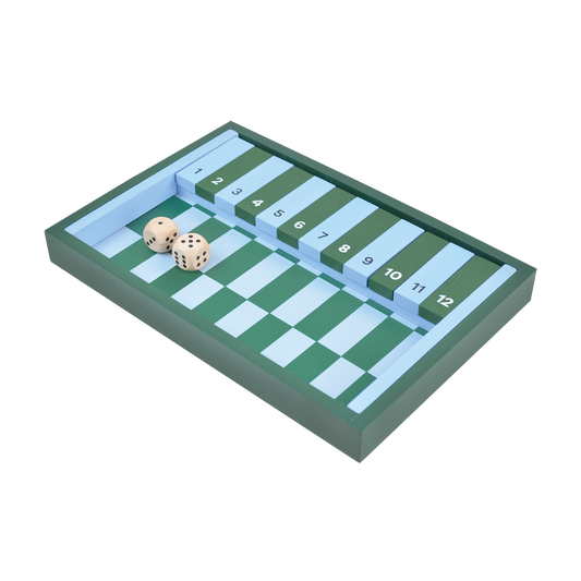 A traditional Shut the Box game set with two dice and wooden hinged tiles laid out on a green and white striped surface.