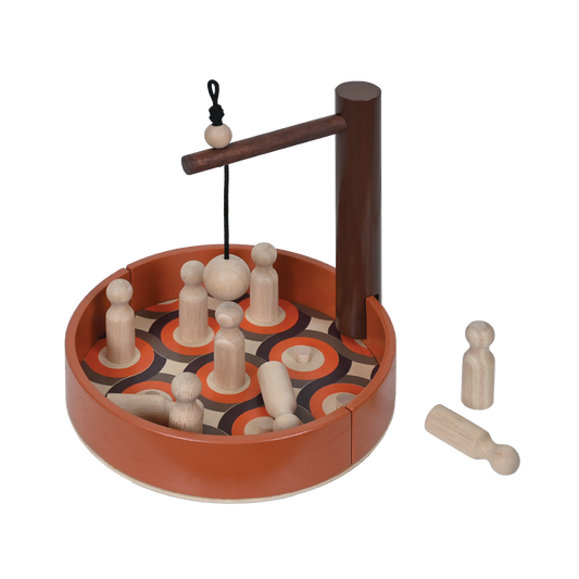 A toy skittle bowling set with a ball and skittles on a brown surface with a wooden frame.