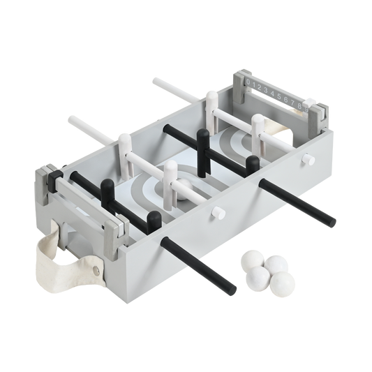 A table football set with a gray playing surface, black and white players, and balls.
