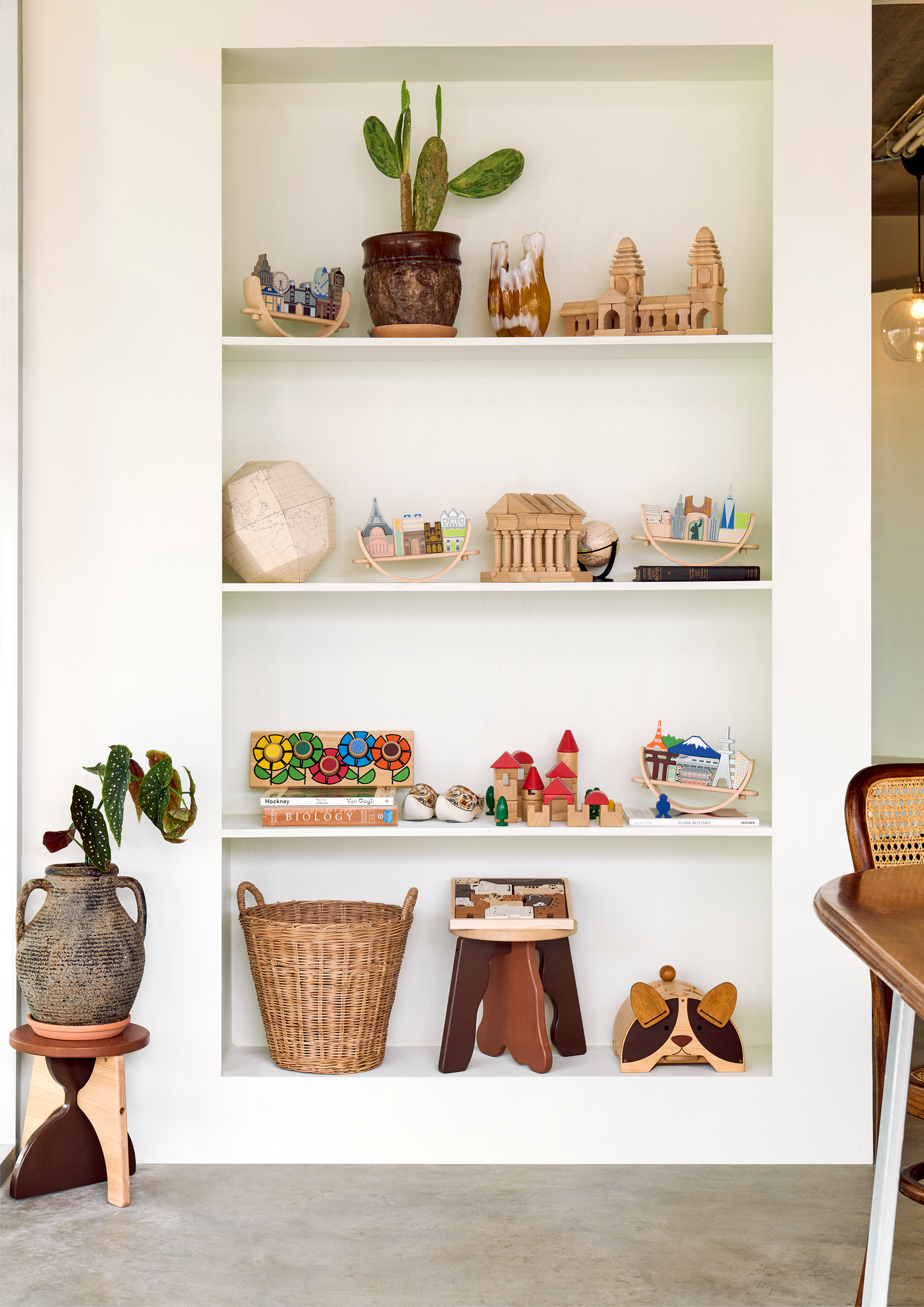A wooden block toy structure resembling a classical building with columns.