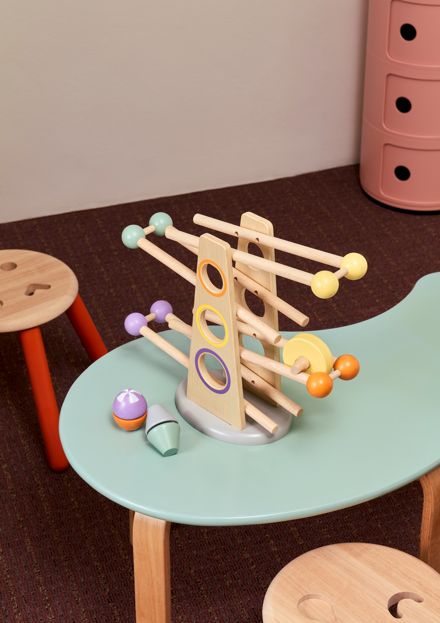 A wooden roller ramp toy with multicolored balls and click clack rollers