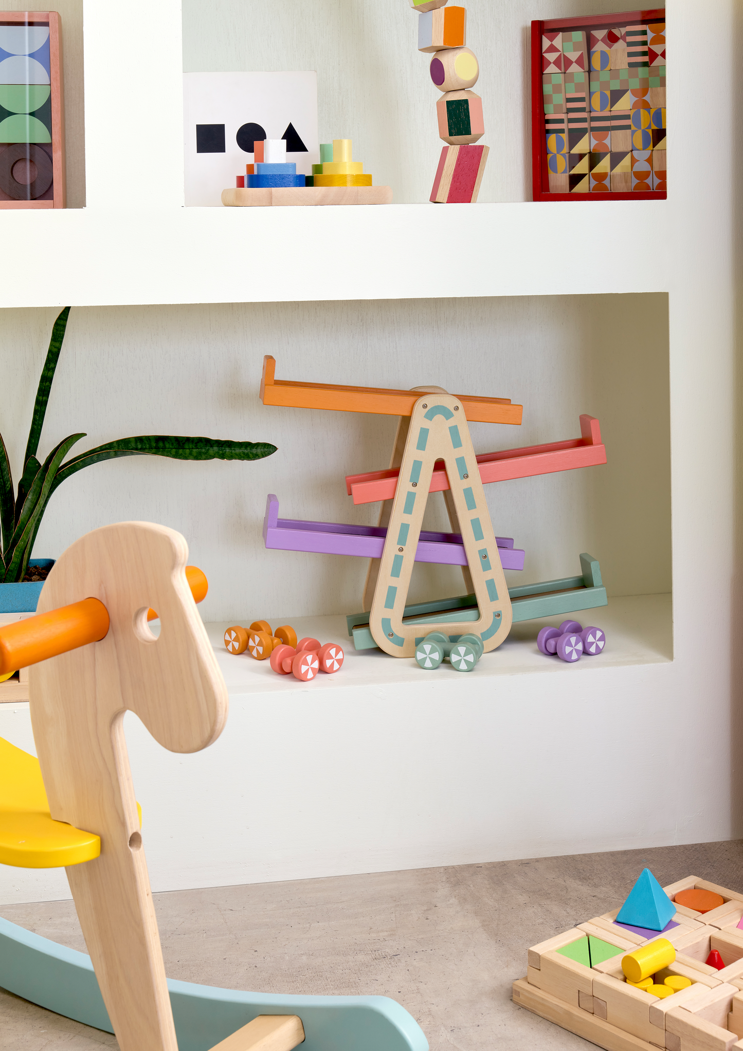 A multicolored totem pole made of wooden blocks, each with a different color and shape, stacked vertically.