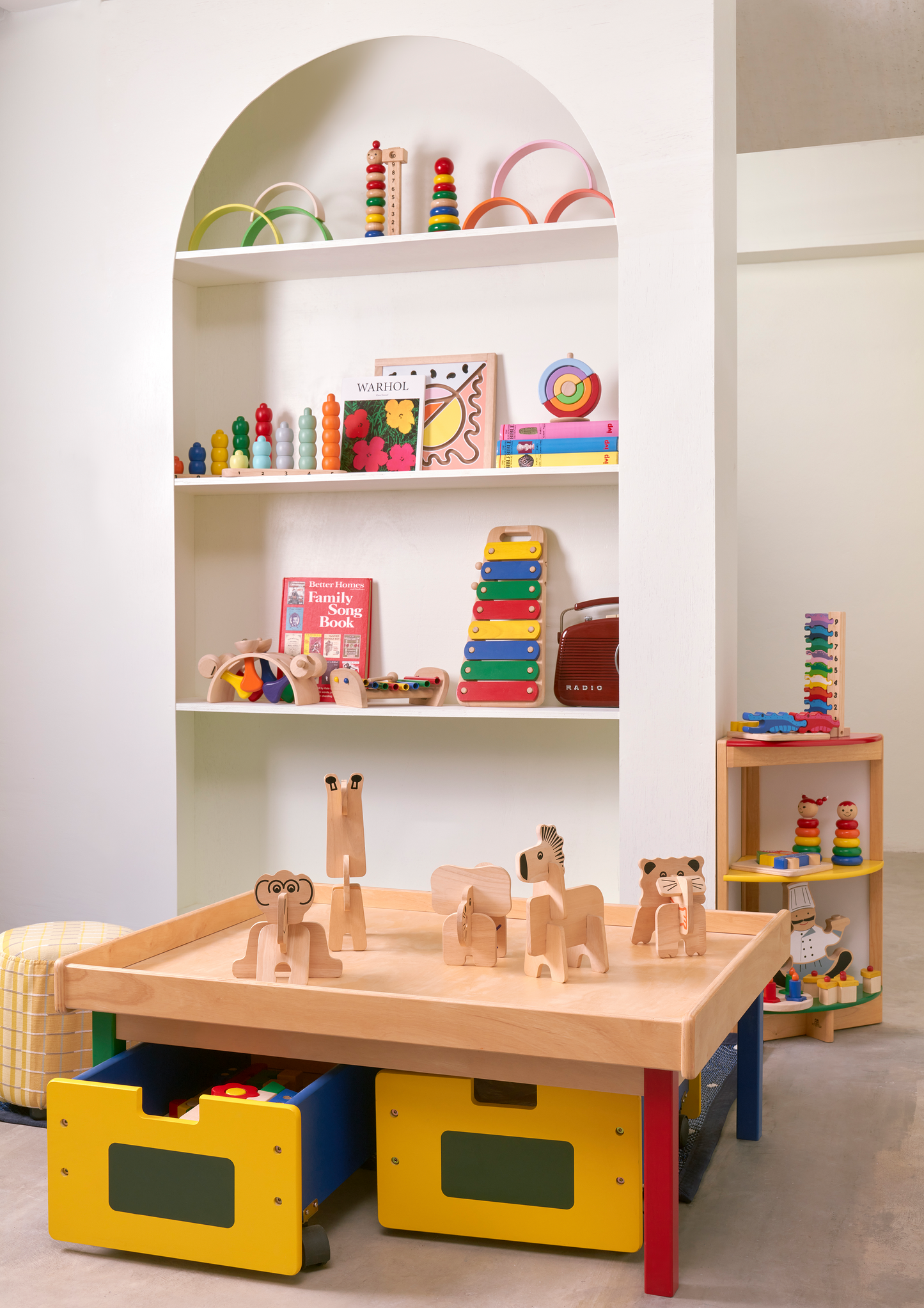 A colorful wooden stacking toy in the shape of a girl with red hair, consisting of a series of wooden rings in different colors.