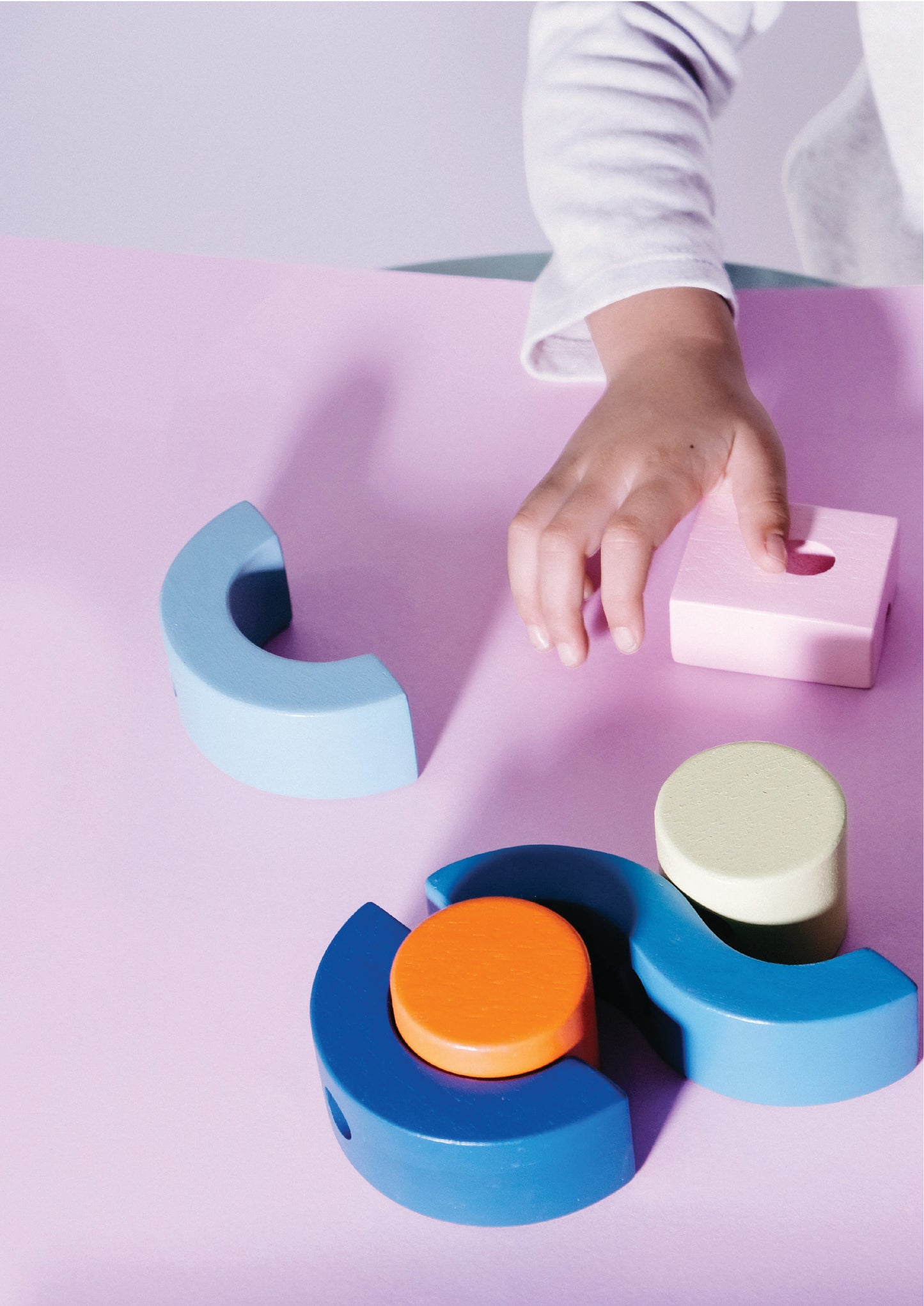 A wooden block toy resembling a segmented circle with red, blue, and green pieces on a wooden base.