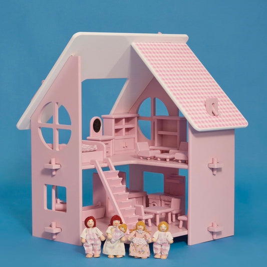 A pink dollhouse with a roof, windows, and a set of stairs. It features a family of five dolls in front, dressed in white with pink accents.