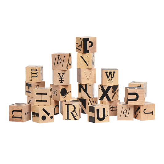 A collection of wooden blocks each printed with a unique graphic letter or symbol, arranged in a pile.