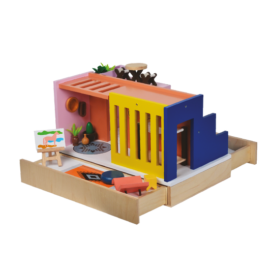 A colorful wooden dollhouse with a red, blue, and yellow facade, containing a doll and some accessories.