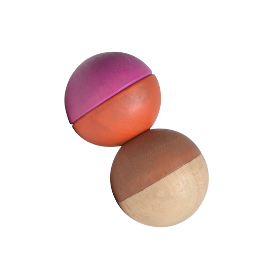 Two spherical rattle toys with a combination of natural wood and pink colors, designed for infants.