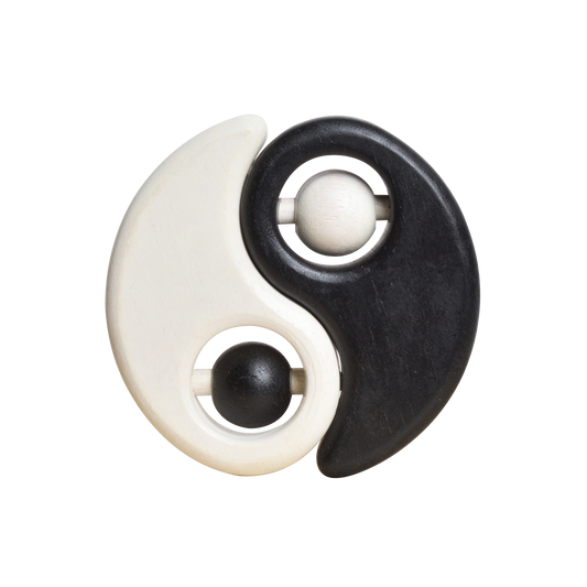 A baby rattle with a white and black color scheme, featuring a spherical shape on one side and a more elongated shape on the other, with a small bead-like object in the center.