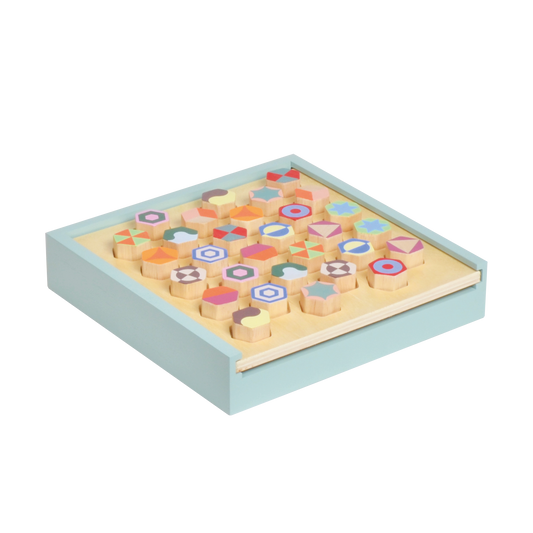 A wooden pattern memory game with multicolored geometric blocks arranged in a box.