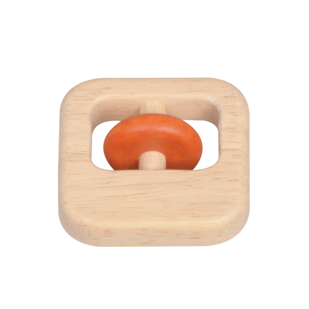A square-shaped wooden rattle with a natural beige color and a red ring in the center.