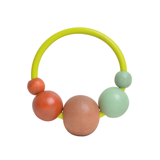 Dark green circular rubber musical shaker with five large wooden beads in brown, orange, and mint green. Encourages children to explore rhythm, differentiate sounds, and develop hand coordination.