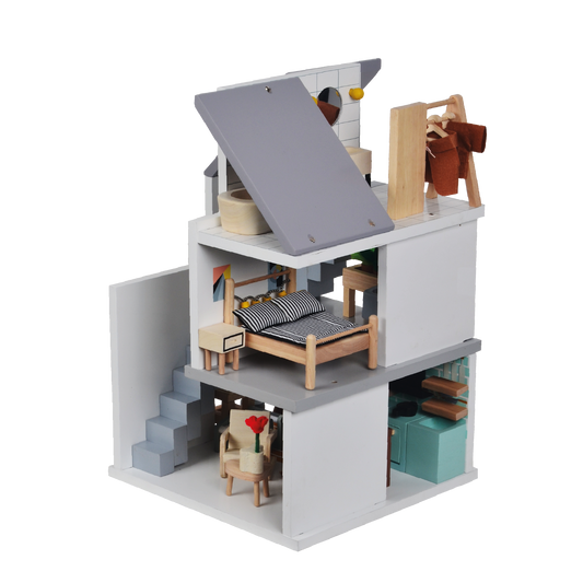 A dollhouse with multiple stories, furnished with Nordic furniture and containing two dolls. One story shows a bed, while another has a seating arrangement.