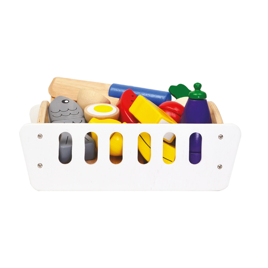 A wooden storage crate filled with colorful toy food items such as egg, fish, banana, watermelon, carrot, eggplant, lemon, and tomato, along with a wooden chopping board and play knife.