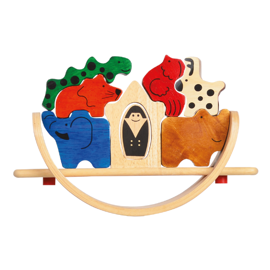 A colorful wooden balance toy in the shape of a boat with animals and a person figurine.