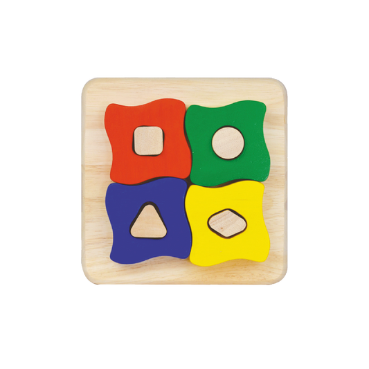 A wooden puzzle with four different shaped blocks in red, green, blue, and yellow colors on a light wooden board.