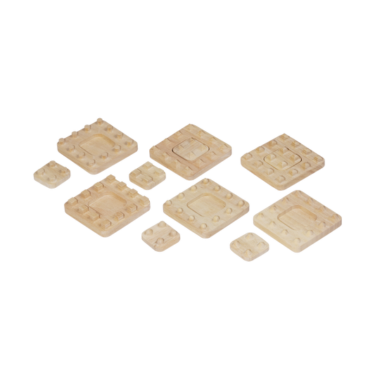 A collection of beige tactile studs of various shapes and sizes arranged on a surface.