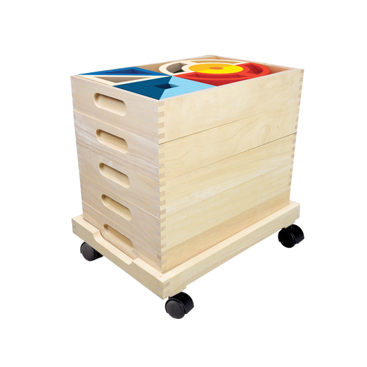 A wooden toy storage unit with multiple compartments, on wheels, containing colorful blocks and shapes for children's play.