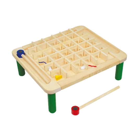A wooden magnetic maze toy with colorful wands and divider pieces on a green table.