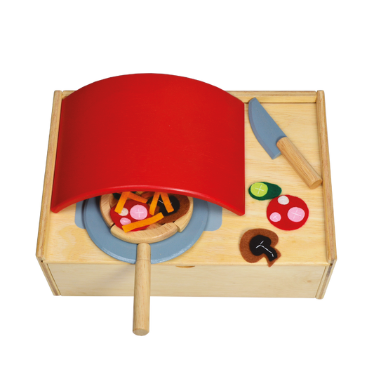 Children's wooden play kitchen set with a red pizza peel, wooden knife, and toy vegetables.
