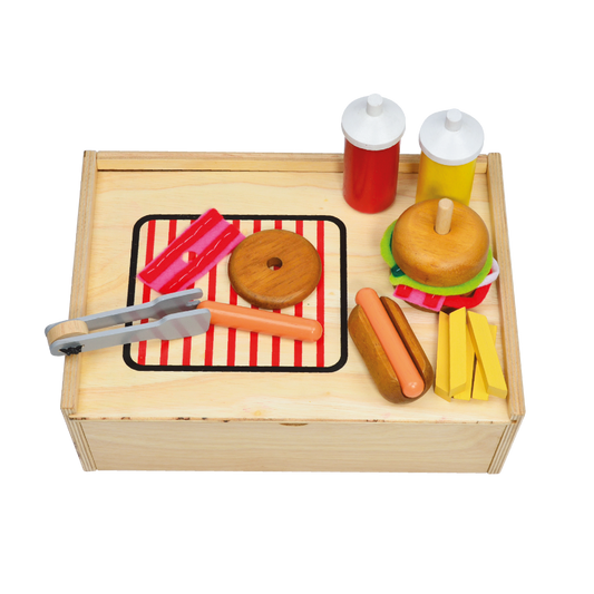 A wooden toy kitchen set featuring a grill, sink, refrigerator, hamburger, hot dog, and fries on a striped mat.