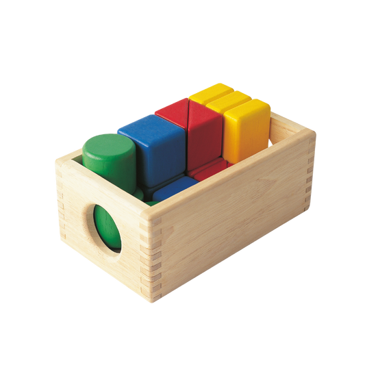 A set of brightly colored wooden blocks arranged in a wooden box.
